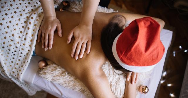 Girl in Christmas hat getting a massage.